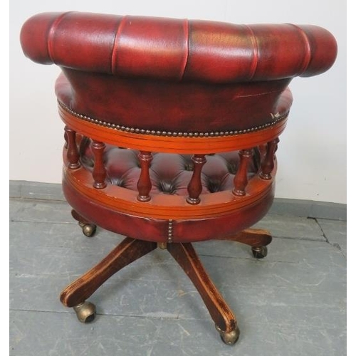 794 - A vintage mahogany Captain’s swivel and reclining desk chair, upholstered in buttoned burgundy leath... 