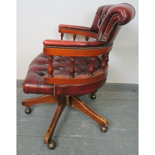 795 - A vintage mahogany Captain’s swivel and reclining desk chair, upholstered in buttoned burgundy leath... 