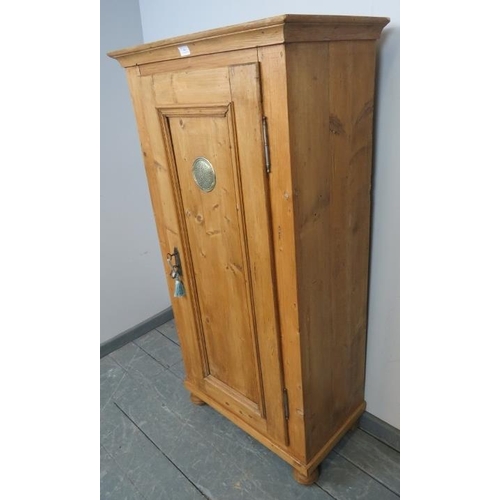 801 - An antique stripped pine pantry cupboard, housing three loose shelves, with panelled door, on bun fe... 