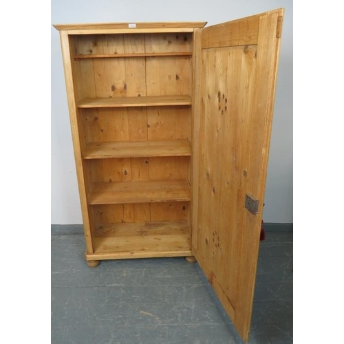 802 - An antique stripped pine pantry cupboard, housing two fitted and two loose shelves, on bun feet.
Con... 