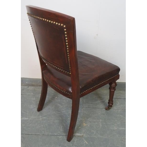 803 - A turn of the century mahogany desk chair upholstered in chocolate brown buttoned brown leather with... 