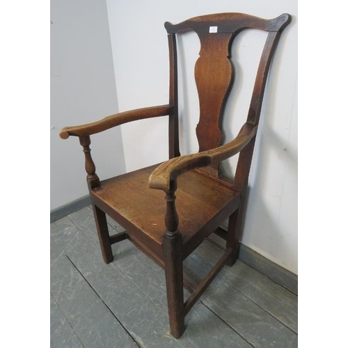 812 - An 18th century elm and oak open sided armchair with shaped back splat and scrolled knuckles, on inn... 