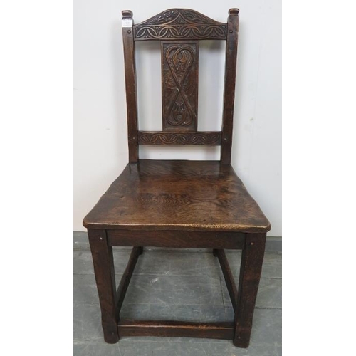 820 - A vintage oak hall chair in a 17th century taste, with relief carved backrest depicting heart motifs... 