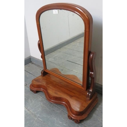 821 - A Victorian walnut swing vanity mirror with shaped uprights and serpentine plinth base, on scrolled ... 