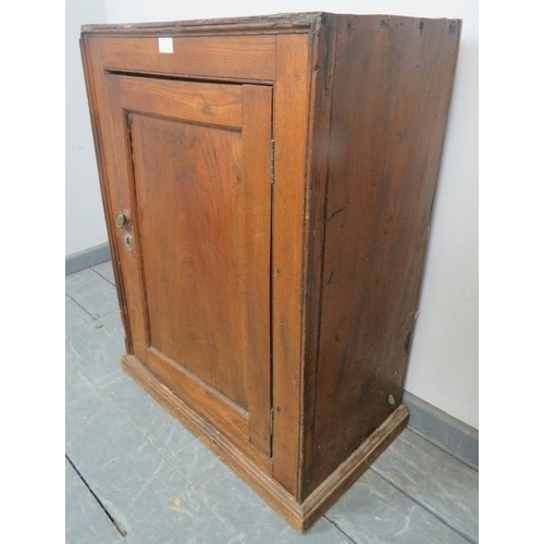 826 - An 18th century elm freestanding cupboard with panelled door and fitted shelf, on a plinth base.
Con... 