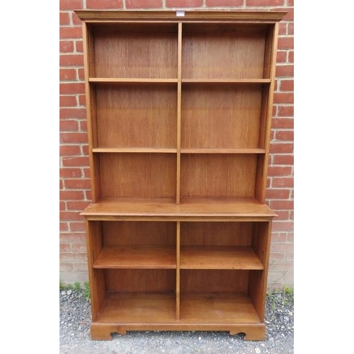 827 - A medium oak tall open bookcase of seven height adjustable shelves, on bracket feet. 
Condition repo... 