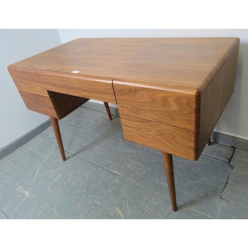 831 - A contemporary walnut desk by Paco, the five long and short drawers with dampened spring-loaded push... 