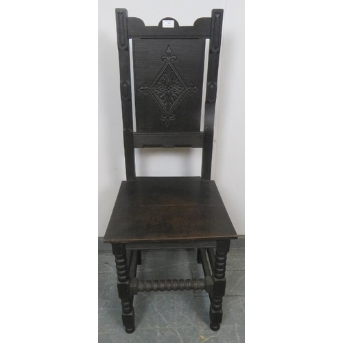 833 - A vintage oak hall chair in the 17th century taste, with carved panel backrest, on ball turned suppo... 