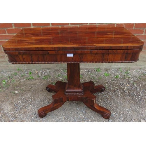 855 - A William IV rosewood turnover card table with inset green baize, featuring gadrooned edging, on a t... 