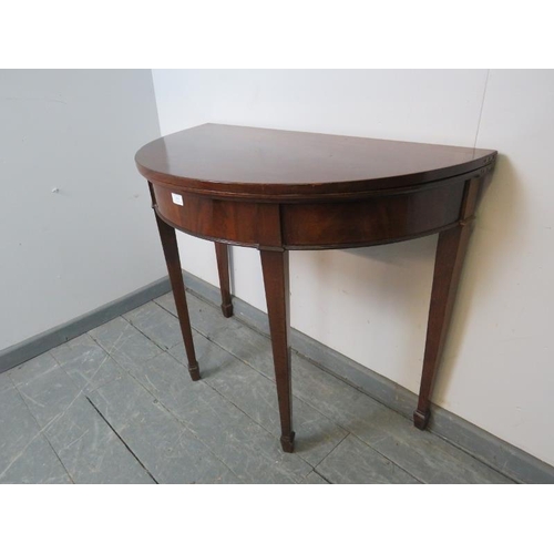 858 - A George III mahogany demi lune folding tea table, on tapering square supports with spade feet. 
Con... 