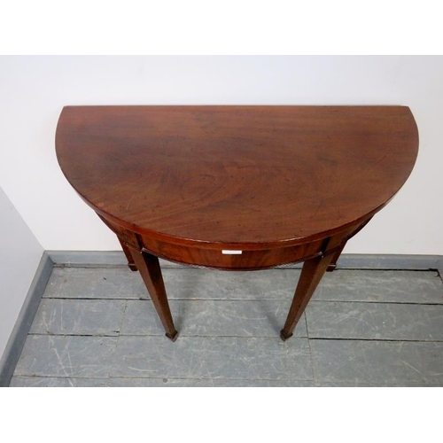 858 - A George III mahogany demi lune folding tea table, on tapering square supports with spade feet. 
Con... 