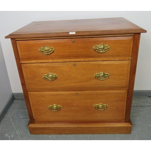 864 - An Edwardian mahogany chest of three long graduated drawers with pressed brass handles, on a plinth ... 