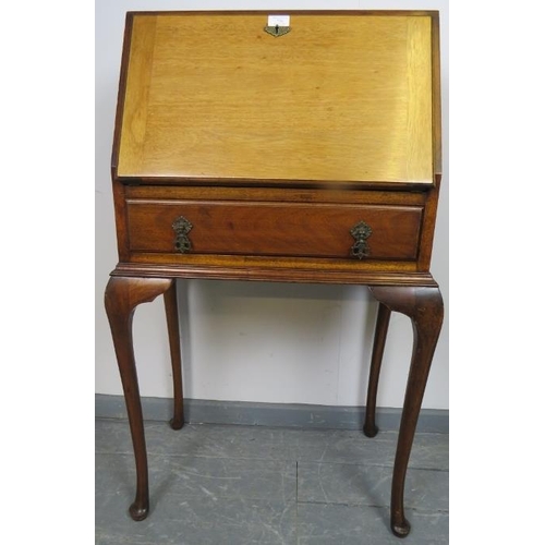 869 - A 1920s mahogany bureau, the fall front opening onto a fitted interior, over one long drawer, on cab... 