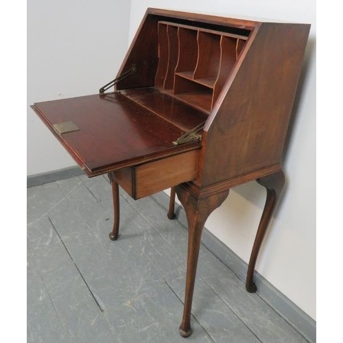 869 - A 1920s mahogany bureau, the fall front opening onto a fitted interior, over one long drawer, on cab... 