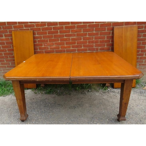 871 - An Arts & Crafts solid light oak wind out extending dining table, with two additional leaves, on tap... 