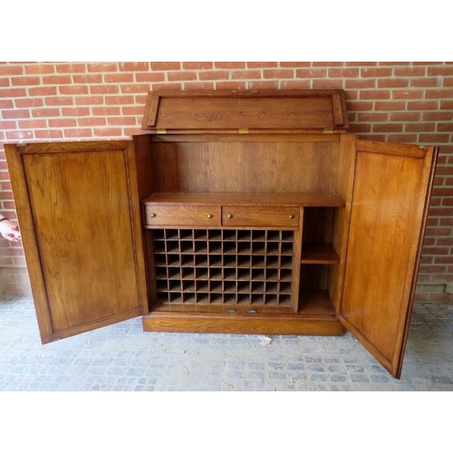 877 - A good quality antique style bespoke golden oak drinks cabinet/bar, the rising lid and double doors ... 