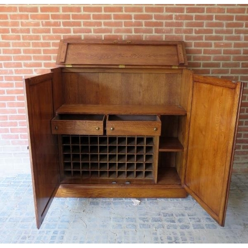 877 - A good quality antique style bespoke golden oak drinks cabinet/bar, the rising lid and double doors ... 