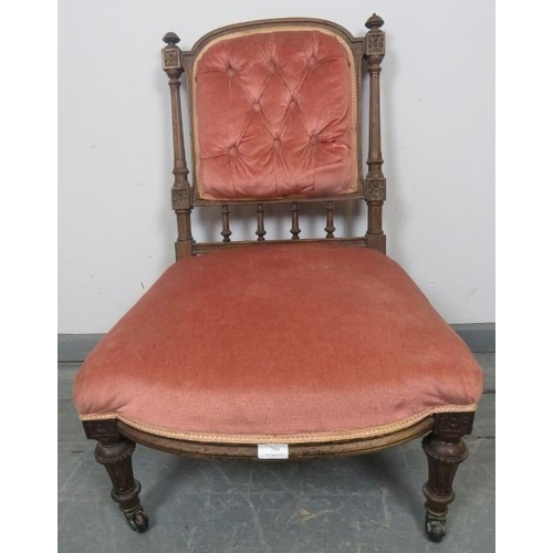 879 - A turn of the century mahogany nursing chair with reeded uprights and finials, upholstered in button... 