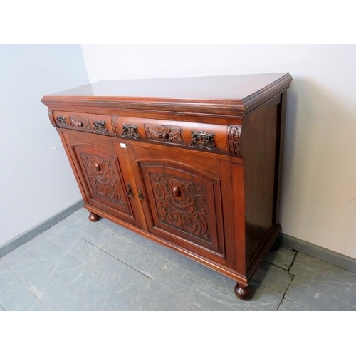 880 - An Art Nouveau mahogany sideboard, the two short drawers with ornately cast handles and relief carvi... 