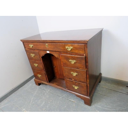 882 - An 18th century oak chest with one long drawer over six graduated drawers and central kneehole with ... 