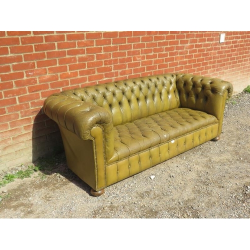 885 - A vintage Chesterfield style three-seater sofa, upholstered in distressed buttoned pea green leather... 