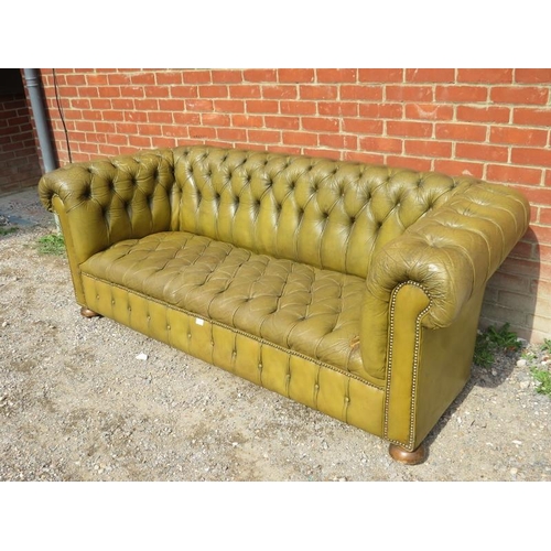 885 - A vintage Chesterfield style three-seater sofa, upholstered in distressed buttoned pea green leather... 