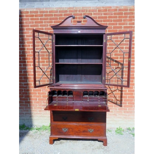 886 - A Georgian Revival secretaire bookcase, featuring scrolled pediment over astral glazed doors opening... 