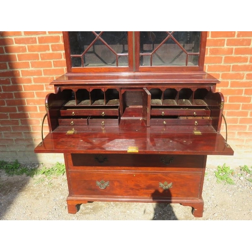 886 - A Georgian Revival secretaire bookcase, featuring scrolled pediment over astral glazed doors opening... 