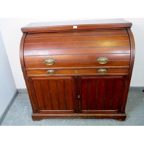 887 - An Edwardian mahogany cylinder desk, the lid opening onto a fitted interior featuring light oak draw... 