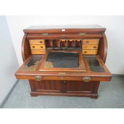 887 - An Edwardian mahogany cylinder desk, the lid opening onto a fitted interior featuring light oak draw... 