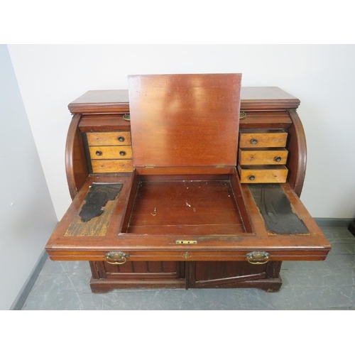 887 - An Edwardian mahogany cylinder desk, the lid opening onto a fitted interior featuring light oak draw... 