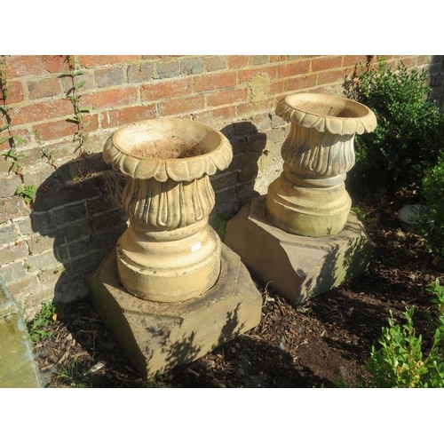 895 - A pair of vintage terracotta garden planters of fluted baluster form, on faceted concrete plinth bas... 