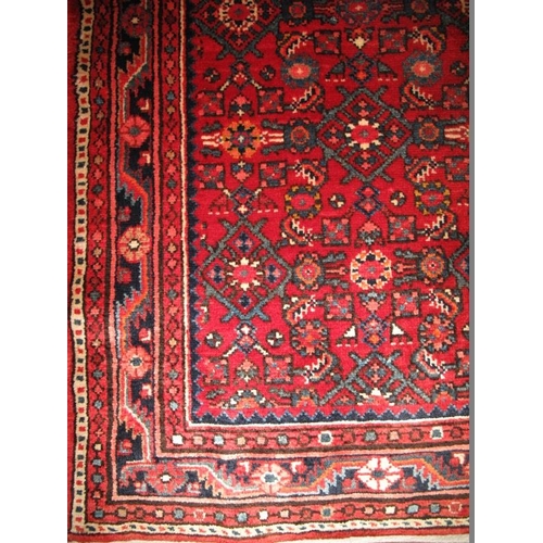 902 - A Persian Malayer runner, decorated with a busy stylised pattern on a red ground between multi-borde... 