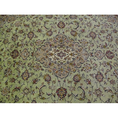 905 - A good Persian Kashan carpet, decorated with a busy scrolling foliate design on a muted pale green g... 