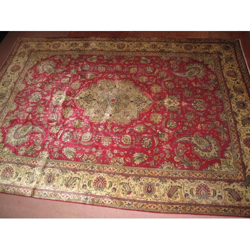 909 - A good Persian Tabriz carpet, decorated with a central medallion amidst stylised foliage on a red gr... 