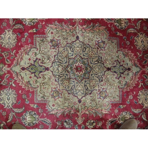 909 - A good Persian Tabriz carpet, decorated with a central medallion amidst stylised foliage on a red gr... 