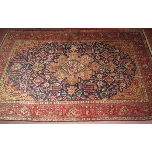 911 - A good Persian Tabriz carpet, decorated with a central shaped muted medallion amidst stylised motifs... 