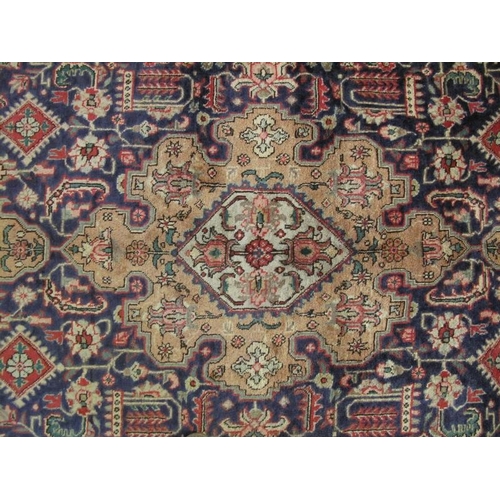 911 - A good Persian Tabriz carpet, decorated with a central shaped muted medallion amidst stylised motifs... 