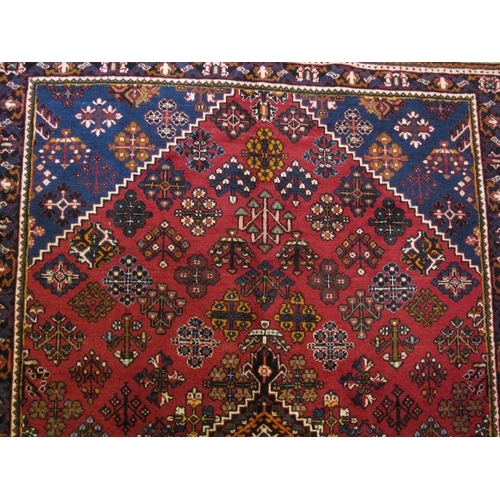 914 - A Persian Josheghan rug, decorated with central lozenge medallion amidst stylised motifs on a predom... 