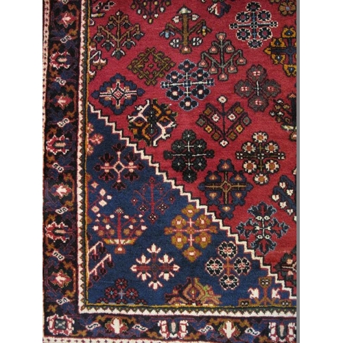 914 - A Persian Josheghan rug, decorated with central lozenge medallion amidst stylised motifs on a predom... 