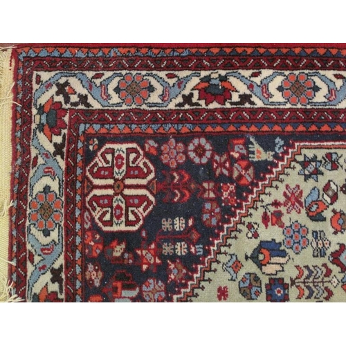 916 - A Persian rug, 20th century, decorated with a central lozenge medallion amidst stylised motifs and s... 