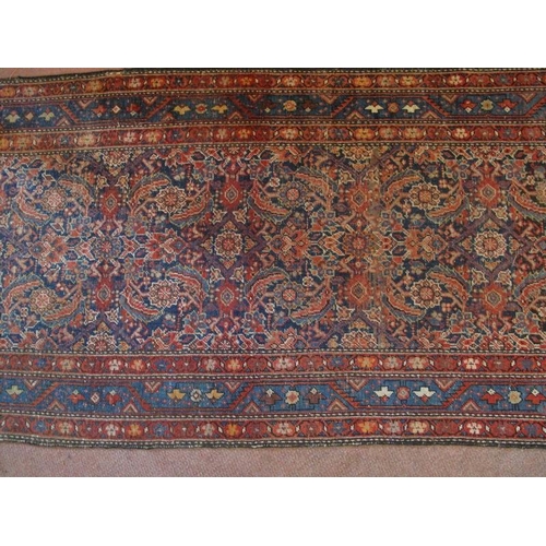 918 - An antique/vintage Persian runner, probably 19th/early 20th century, decorated with a busy stylised ... 