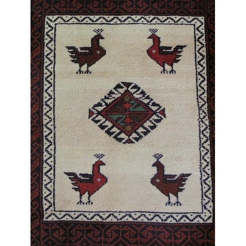 919 - A small vintage Persian rug, decorated with a central panel of birds, and lozenge on an ivory ground... 