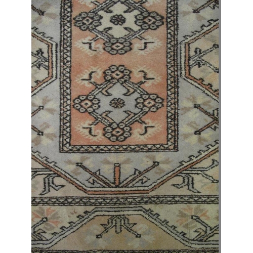 920 - A vintage Persian rug decorated with all over stylised motifs within borders, on pale muted grounds,... 