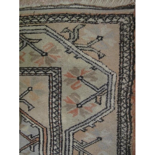 920 - A vintage Persian rug decorated with all over stylised motifs within borders, on pale muted grounds,... 