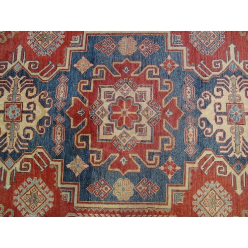 922 - A Persian rug, 20th century, 100% woven wool, decorated with stylised traditional motifs on red, blu... 