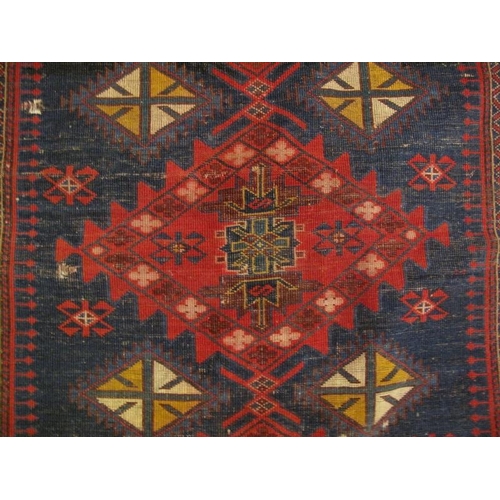 925 - An antique Persian rug decorated with a central field of traditional lozenge motifs within multi-bor... 