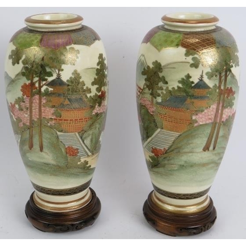 13 - A pair of finely decorated Japanese Satsuma vases with traditional Mount Fuji scenes standing on tur... 