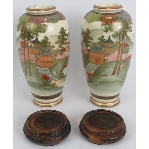 13 - A pair of finely decorated Japanese Satsuma vases with traditional Mount Fuji scenes standing on tur... 