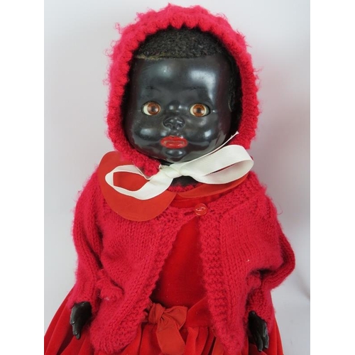 134 - A vintage 1950s pedigree black doll with red dress and bonnet and a 1970s 'Roddy' black plastic doll... 